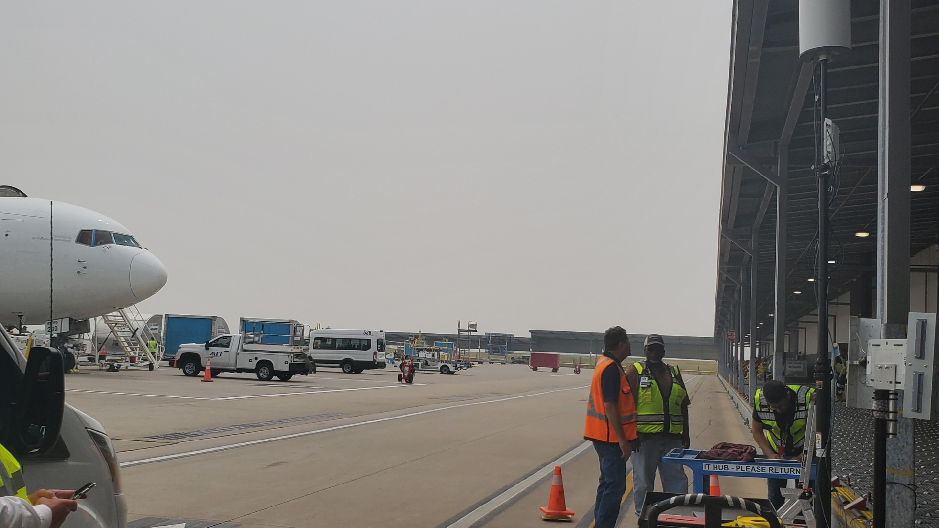 Ground crew on an air cargo ramp beside a mounted Apogee array